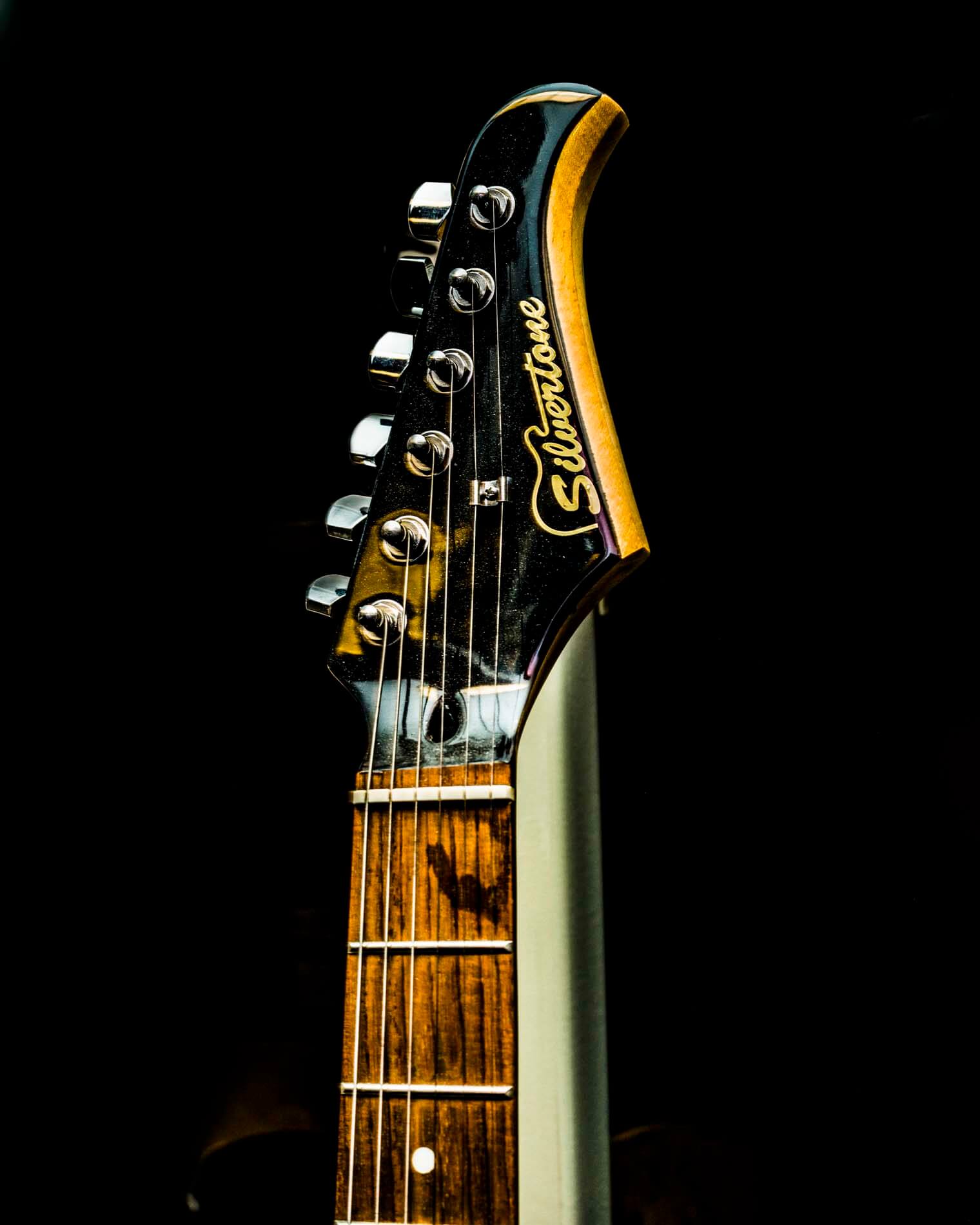 Silvertone guitar shot against a black background