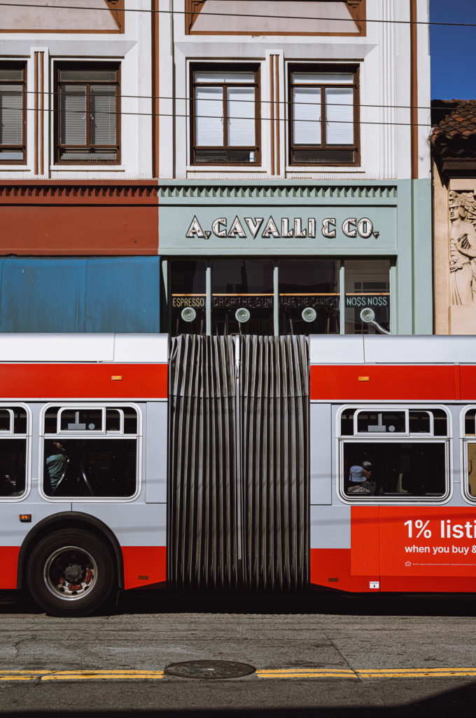 At the corner of a bustling avenue, an articulated bus, painted in bold strokes of red and white, glided past, momentarily interrupting the steady rhythm of pedestrians. Above a dated yet dignified storefront, a sign proudly proclaimed "A. Cavalli & Co.," its serifed letters evoking both heritage and promise.

The building's façade was adorned with multi-panel windows that bore the secrets of countless transactions and whispered conversations. Intricate decorative details ran along its periphery—a vestige from an era when craftsmanship was synonymous with integrity.

As the bus journeyed on its route, an advertisement imprinted on its side caught my eye: "1% listing fee when you buy & sell." The words felt both starkly transactional and oddly comforting in their straightforwardness—an emblematic promise in this city where tradition entwined itself seamlessly with transformation.
